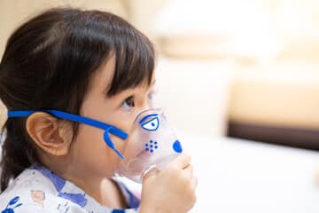 Girl with an oxygen mask awaiting action from healthcare professionnal.