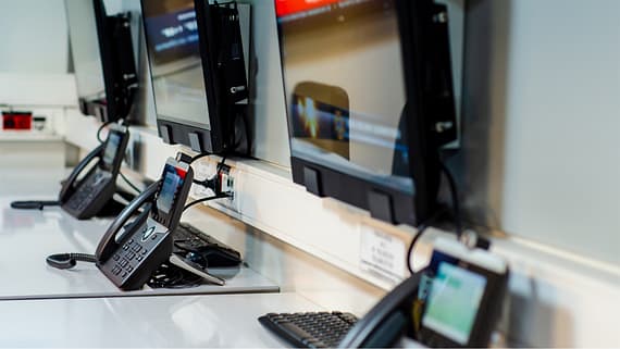 A picture of telephones and desktops on a table.